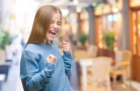 年轻漂亮的女孩穿着冬天的毛衣,在孤立的背景下,非常高兴和兴奋地做着