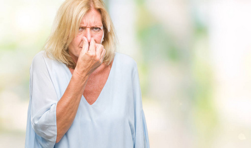 放屁中间中年金发商务女性在孤立的背景上闻到了一些臭味和令人恶心的