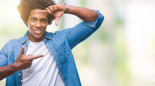 美国黑人男子在孤立的背景上微笑，用手和手指制作框架，用快乐的脸。 创造力和摄影理念。
