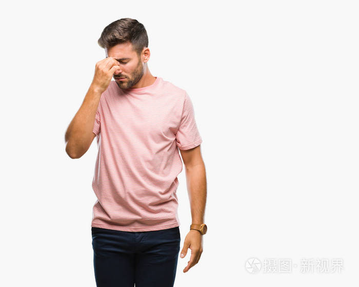 年轻英俊的男人在孤立的背景下疲惫地揉着鼻子和眼睛,感到疲劳和头痛.