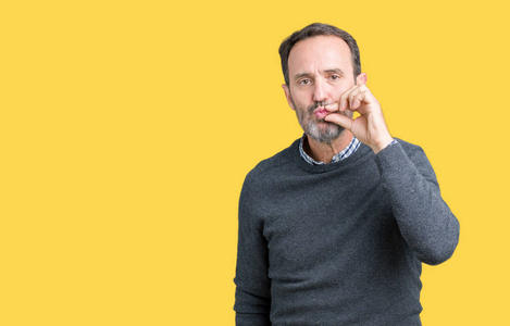 拉链嘴英俊的中年老人穿着毛衣,在孤立的背景嘴和嘴唇上闭上,用手指