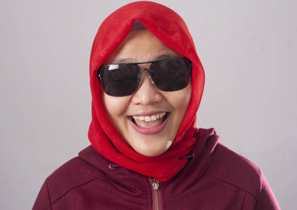 戴着黑色太阳镜,穿着红色西装,戴着头巾,笑着,努力,快乐的表情,近距离