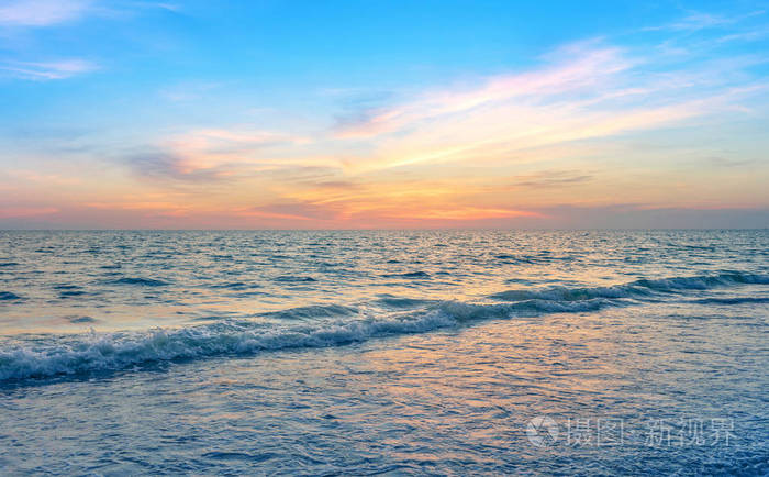 美丽的日落天空，海浪在放松的度假时间，平静的海景在五彩缤纷的晚霞中