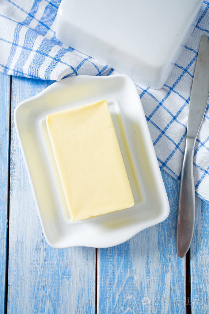 蓝色木制表面的黄油盘
