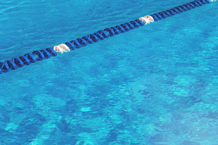 带有复制空间和选择性聚焦的蓝色穿孔带车道标记的游泳池水