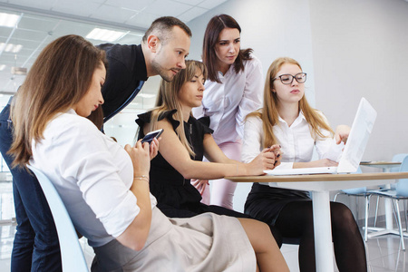 办公室工作人员队伍..商业女性和男性坐在桌子旁边，拿着笔记本电脑，计划未来公司的概念。团队合作。两性平等。