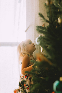 家中圣诞树旁可爱的小女孩