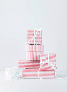 堆叠新生礼物。 白色背景上的节日粉红色。 复制空间。 垂直垂直垂直