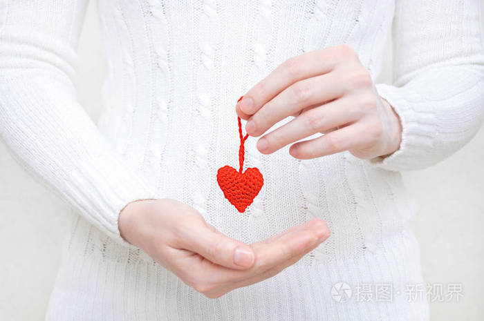 女孩手里拿着一颗红色的羊毛心快关门
