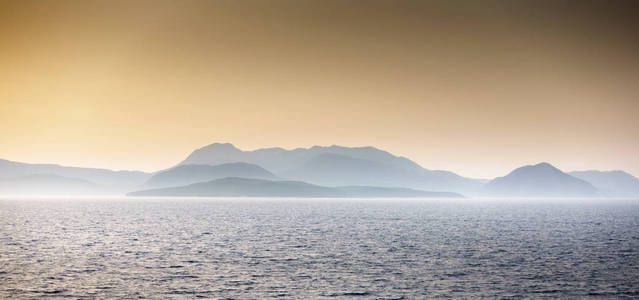 希腊日落时海景对山景