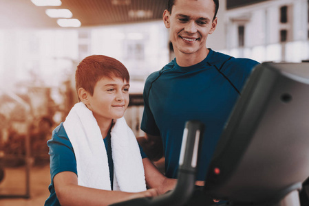 健身房跑步机中的年轻父子训练