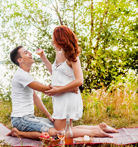野餐的快乐年轻夫妇。
