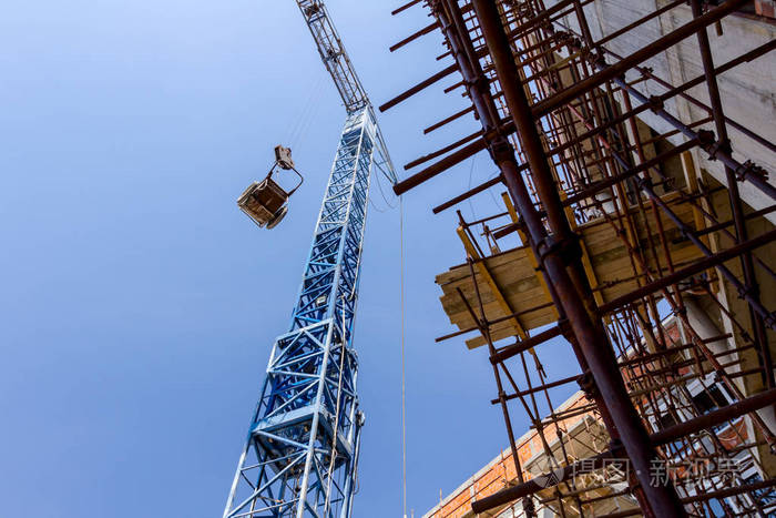 起重机是用手推车在建筑工地上方的绳索上拉起的