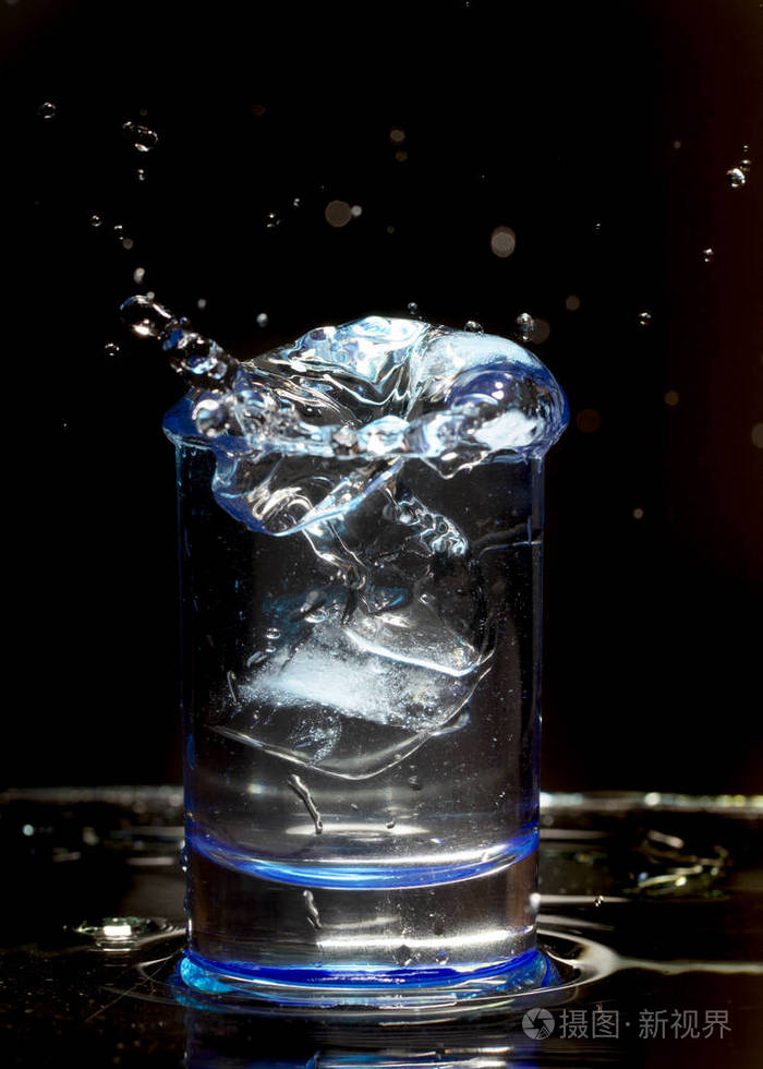 一杯威士忌,在黑色背景上溅上水花