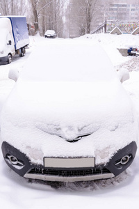 汽车覆盖着新鲜的白雪，汽车在暴风雪后被雪覆盖