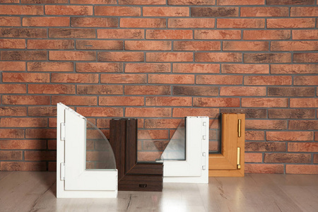 地面靠砖墙的现代窗型材样品。安装服务