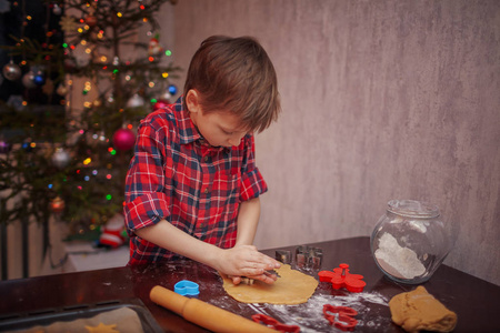 可爱的小男孩正在圣诞节厨房里准备姜饼饼干