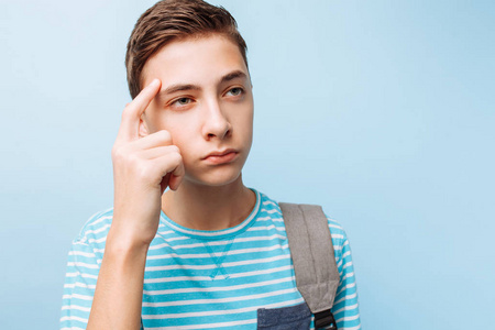 忧郁的青少年男子蓝色背景照片