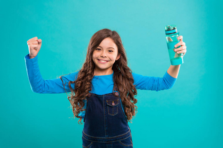 健康和水分。女孩关心健康和水的平衡。女孩欢快举行水瓶蓝色背景。孩子女孩长发有水瓶。水平衡概念。强壮健康的孩子