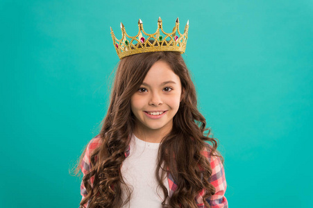 孩子戴着公主的金冠象征。女孩可爱的婴儿戴皇冠, 而站蓝色背景。成为公主的概念。每个梦想成为公主的女孩。小公主夫人梦想成真