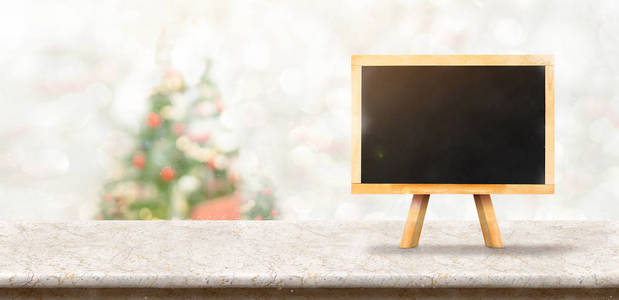 黑板白色大理石桌面在模糊的波克圣诞树装饰与弦光背景时显示下降，寒假贺卡。