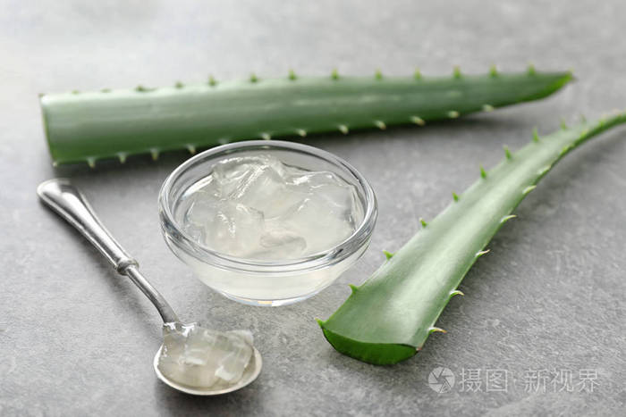 碗中芦荟果肉,灰桌上有鲜叶