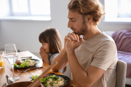 父亲和女儿在家吃饭前祈祷