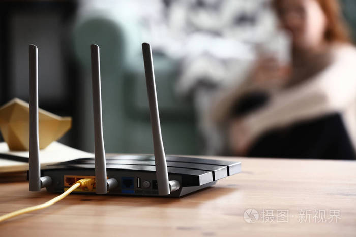 室内木制桌子上的现代Wi Fi路由器