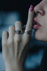 女人嘴唇上戴着银环的手指