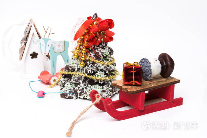 节日桌上的巧克力圣诞树，玩具鹿，木制雪橇，礼品，花环，复印空间