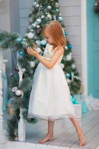 穿着白色衣服的漂亮孩子装饰圣诞树打开礼物
