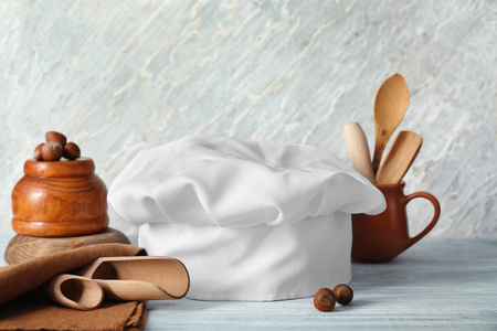 s hat with  kitchenware on wooden table