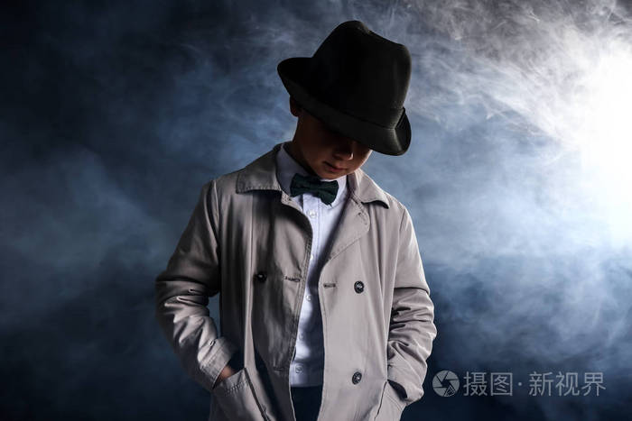 在黑暗背景下抽烟的可爱小侦探