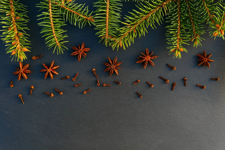 圣诞树云杉枝和八角和丁香的星星在石头背景上。