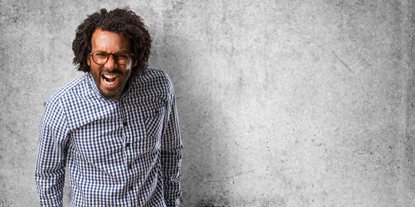 英俊的商业非裔美国男人尖叫愤怒,疯狂的表情和精神不稳定,张开嘴和半