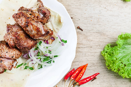 关闭顶部视图烤牛肉片粉碎与草药和香料在白色盘子。肉，蔬菜。食谱食品。美味的烧烤菜肴。文本复制空间