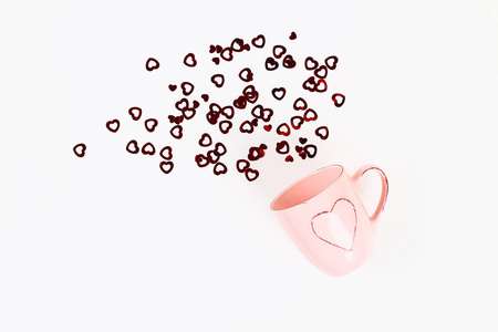 情人节的布局。 粉红色的杯子，在白色的背景上离开的心。 情人节爱情2月14日概念。 平面布局构成