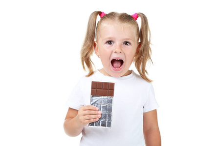 快乐的小女孩在白色背景下吃巧克力