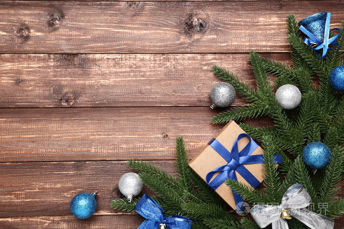 圣诞树树枝上有礼品盒和棕色木桌上的