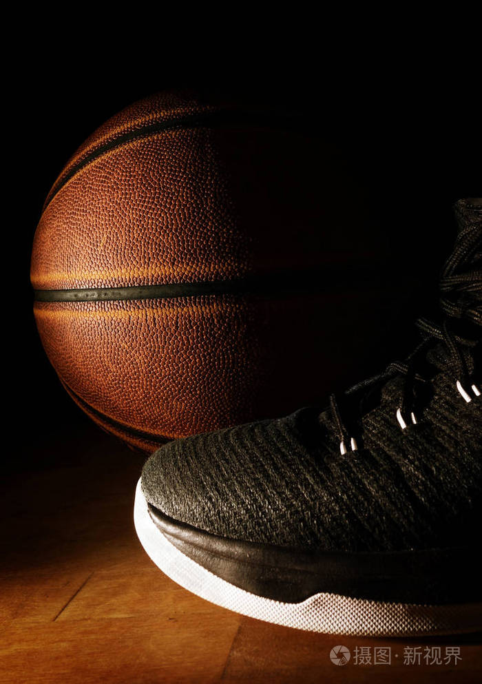 球场上黑色背景的篮球鞋和球