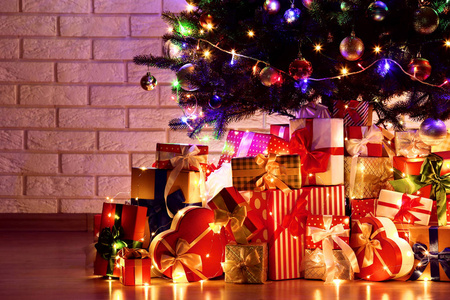 用砖墙背景装饰和礼品盒照亮圣诞树