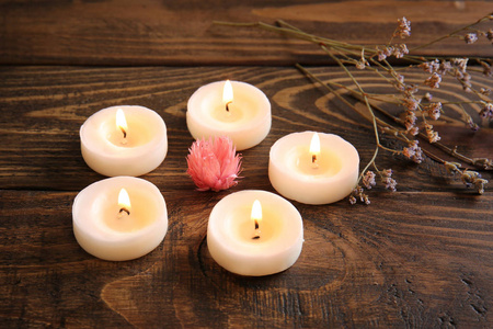 在木桌上燃烧蜡烛和鲜花