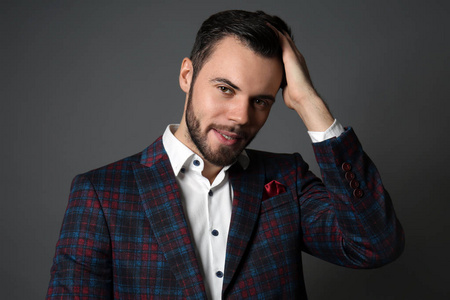 穿着灰色背景正式服装的时髦年轻人照片