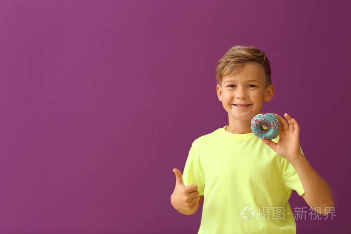 可爱的小男孩带着甜甜圈出现在彩色背景上