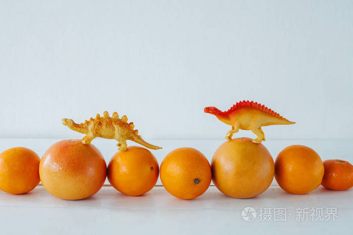 孤立的柑橘类水果. 葡萄柚柑桔在白色背景上分离. 恐龙玩具.