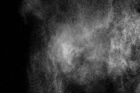 白色粒子在黑色背景上的冻结运动。 粉末爆炸。 抽象灰尘覆盖纹理。