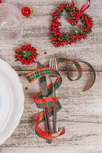 冬天的地方设置圣诞节和新年装饰在白色的木制桌子上。 圣诞晚餐的节日餐桌设置。