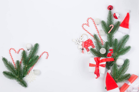 圣诞节装饰背景与红白圣诞礼物球和玩具冷杉树枝锥白色背景。 卡假日概念。 复制空间顶部视图。
