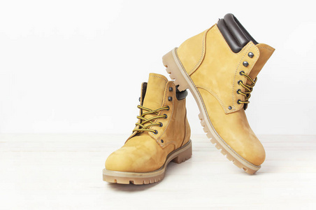 s work boots from natural nubuck leather on wooden white backgro