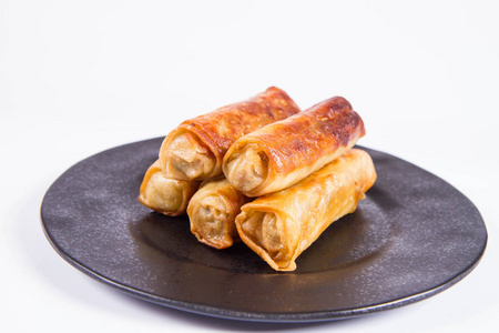 小菜板中国传统的弹簧卷在黑色盘子上照片